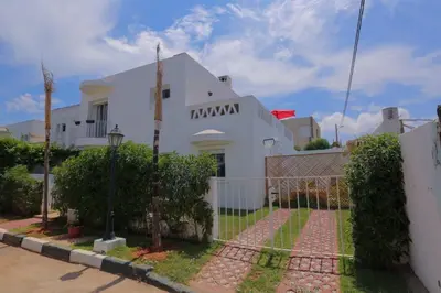 a white house with a fence in front of it at Chez Didier Tamaris Beach in Dar Bouazza