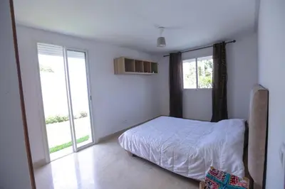 a bedroom with a bed and a large window at Chez Didier Tamaris Beach in Dar Bouazza