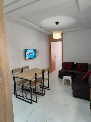 a living room with a table and a couch at My Cosy Place Rabat - RABAT AGDAL GARE TGV ARRIBAT Center in Rabat
