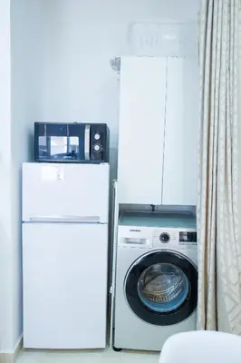 a white refrigerator and a washing machine in a room at My Cosy Place Rabat - RABAT AGDAL GARE TGV ARRIBAT Center in Rabat