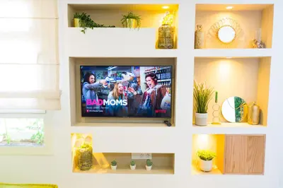 a television on a wall in a living room at My Cosy Place Rabat - RABAT AGDAL GARE TGV ARRIBAT Center in Rabat