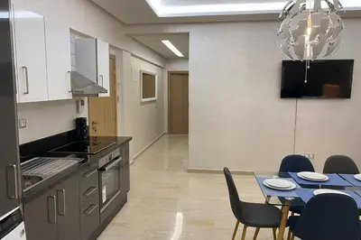 a kitchen and dining room with a table and chairs at Du Haut Standing au coeur du Parc et Plage à 180 m in Mohammedia