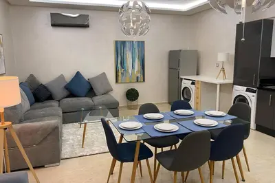 a living room with a blue table and chairs at Du Haut Standing au coeur du Parc et Plage à 180 m in Mohammedia
