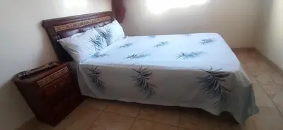 a bed with a white comforter with feathers on it at Maison de la famille in Casablanca