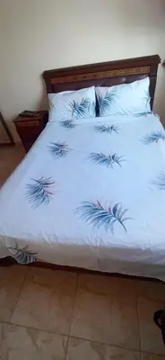 a white bed with blue feathers on it at Maison de la famille in Casablanca