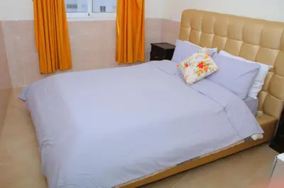 a bedroom with a large bed with orange curtains at Bouznika 22 in Bouznika