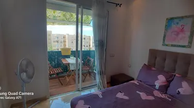 a bedroom with a bed and a balcony with a view at appartement Shems Bouznika Premium in Bouznika