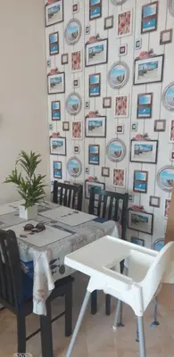a dining room with a table and chairs and a wall with plates at appartement Shems Bouznika Premium in Bouznika