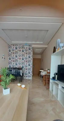 a living room with a table and a dining room at appartement Shems Bouznika Premium in Bouznika