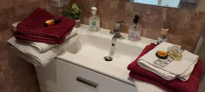 a bathroom sink with red towels on it at appartement Shems Bouznika Premium in Bouznika