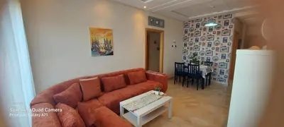 a living room with a brown couch and a table at appartement Shems Bouznika Premium in Bouznika