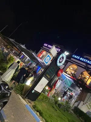 a gas station with people standing outside at night at Mansbay Beach, Vue sur Mer, accès Plage à pied, Mohammedia in Mohammedia