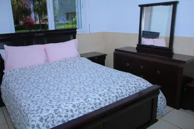 a bedroom with a bed with a mirror and a dresser at L Appartement évasion in Mohammedia