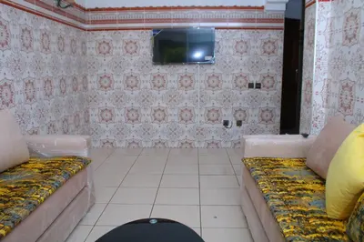 a room with a couch and a tv on a wall at L Appartement évasion in Mohammedia