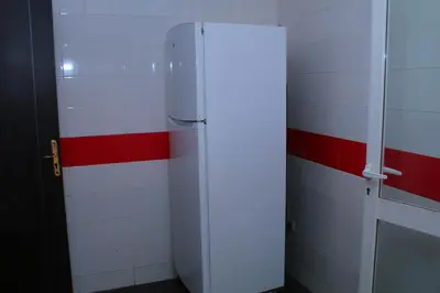 a bathroom with a refrigerator and red and white tiles at Les charmes de la Campagne de Bouznika in Bouznika