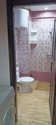 a bathroom with a toilet and pink wallpaper at Studio meublé Casablanca in Casablanca