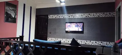 a living room with a couch and a tv on a wall at Studio meublé Casablanca in Casablanca