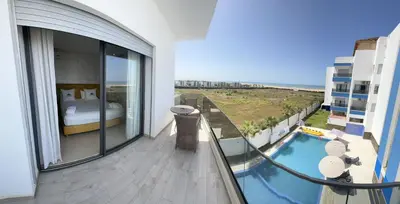 a balcony with a view of a bedroom and a pool at CASA BEACH HOTEL in Sidi Rahal