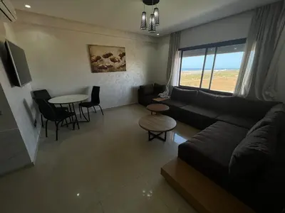 a living room with a couch and a table at CASA BEACH HOTEL in Sidi Rahal