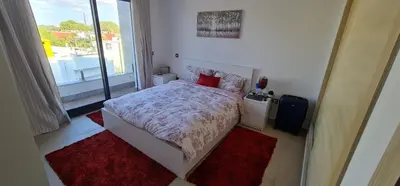 a bedroom with a bed and a large window at Appartement neuf haut standing vue mer in Skhirat