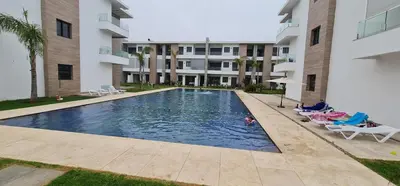 a swimming pool in front of a building at Appartement neuf haut standing vue mer in Skhirat
