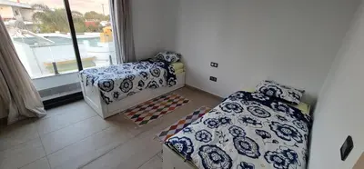 a small room with two beds and a window at Appartement neuf haut standing vue mer in Skhirat