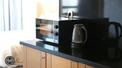 a microwave sitting on top of a black counter at Maarif Home Casablanca in Casablanca
