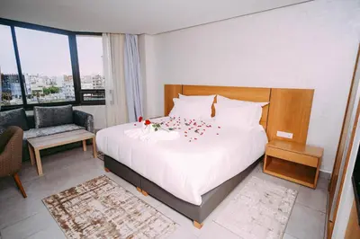 a bedroom with a large white bed with decorations on it at Maarif Home Casablanca in Casablanca