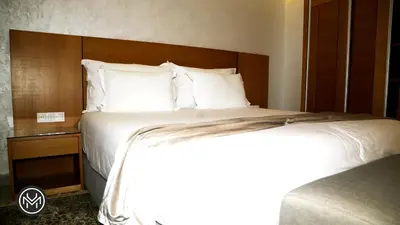 a bedroom with a large bed with a wooden headboard at Maarif Home Casablanca in Casablanca