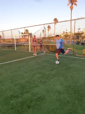a man kicking a soccer ball on a tennis court at Appartement au Bord de la Mer in Casablanca