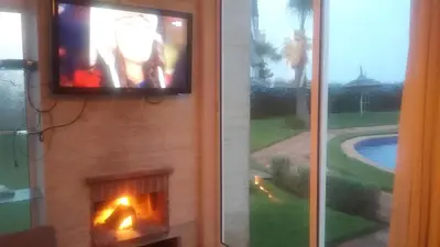 a television on a wall next to a fireplace at Appartement au Bord de la Mer in Casablanca