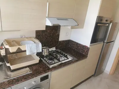 a kitchen with a sink and a counter top at Casabay Appart Vue Sur Piscine in Sidi Rahal