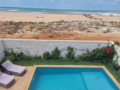 a swimming pool with a view of the beach at La petite villa avec piscine pieds dans l'eau in Sidi Rahal