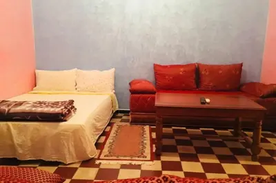 a room with a bed and a couch and a table at Nice 2 Bedrooms Apartment near the beach in Rabat