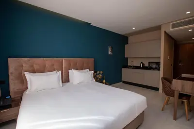 a bedroom with a large bed and a blue wall at Address Hotel Casablanca in Casablanca