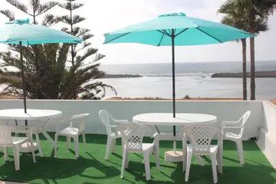 two tables and chairs with umbrellas on a patio at La Grande Proprit toile De Mer in Skhirat