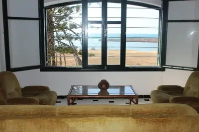 a room with a table and some chairs and windows at La Grande Proprit toile De Mer in Skhirat