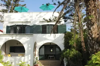 a white house with arches and trees at La Grande Proprit toile De Mer in Skhirat