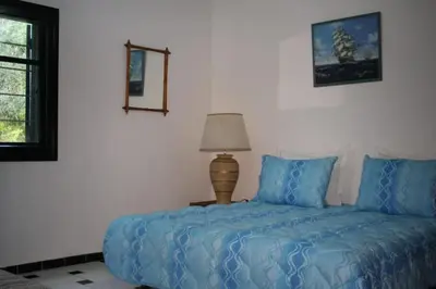 a bedroom with a bed with blue sheets and a lamp at La Grande Proprit toile De Mer in Skhirat