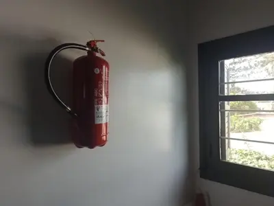 a fire extinguisher hanging on a wall next to a window at Maison Etoile De Mer 2 in Skhirat