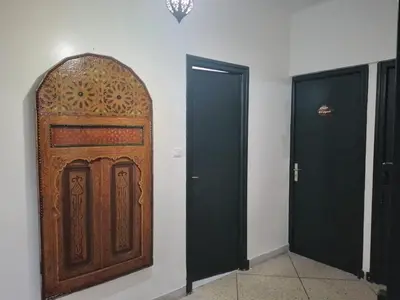 a large wooden door in a room with two doors at Maison Etoile De Mer 2 in Skhirat