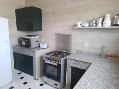 a kitchen with a stove and a counter top at Maison Etoile De Mer 2 in Skhirat