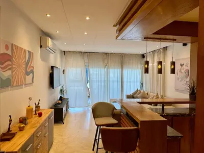 a kitchen and living room with a table and chairs at Peninsula Dar Bouazza Superbe appartement en résidence avec piscine activités in Dar Bouazza