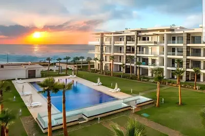an aerial view of a resort with a swimming pool and the ocean at Appartement de luxe en bord de mer avec piscine in Mansouria