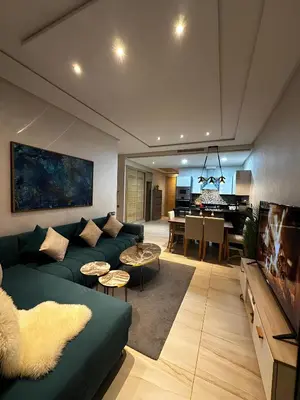 a living room with a green couch and a piano at Appartement de luxe en bord de mer avec piscine in Mansouria