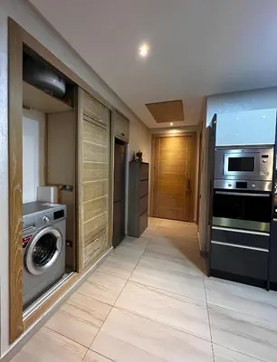 a kitchen with a washing machine and a washer and dryer at Appartement de luxe en bord de mer avec piscine in Mansouria