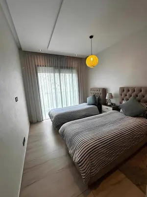 a bedroom with two beds and a window at Appartement de luxe en bord de mer avec piscine in Mansouria