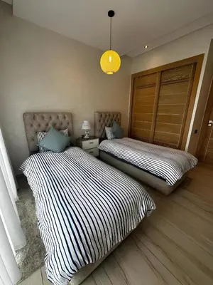 two beds sitting in a room with at Appartement de luxe en bord de mer avec piscine in Mansouria