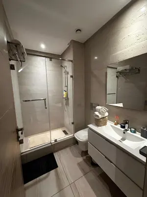 a bathroom with a shower and a toilet and a sink at Appartement de luxe en bord de mer avec piscine in Mansouria