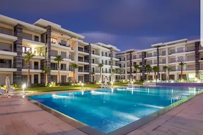 an image of a swimming pool in front of a building at Appartement de luxe en bord de mer avec piscine in Mansouria